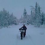 César Riera empujando su bici por los bosques de Laponia