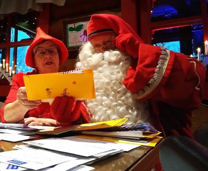 Papá Noel y un Elfo leyendo una de las miles de cartas que recibe cada año