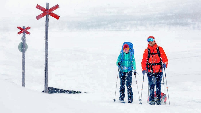 Esquiadores-siguiendo-las-marcas-de-una-carretera-de-moto-de-nieve-en-Kasivarsi_fotoRamiValone-Luontoon
