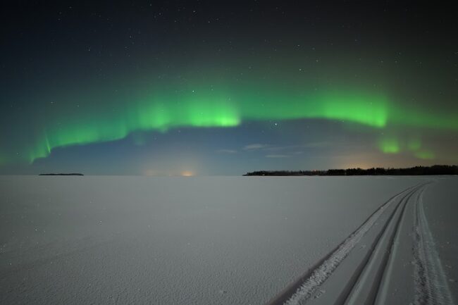 Aurora-Boreal-sobre-un-lago-en-Laponia_fotoThomasKast-VisitFinland